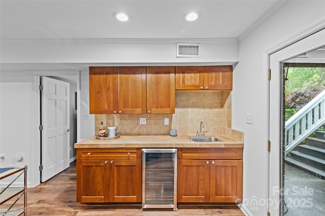 2418 Ainsdale Rd, Charlotte, NC 28226 - kitchen featuring beverage cooler, ornamental molding, a sink, light countertops, and backsplash
