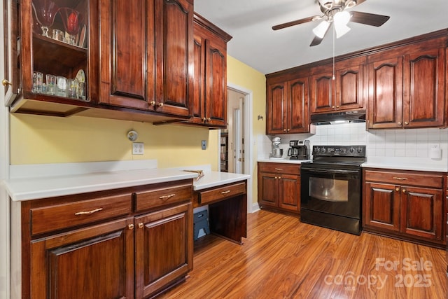 kitchen with a ceiling fan, tasteful backsplash, light wood-style floors, under cabinet range hood, and black range with electric cooktop