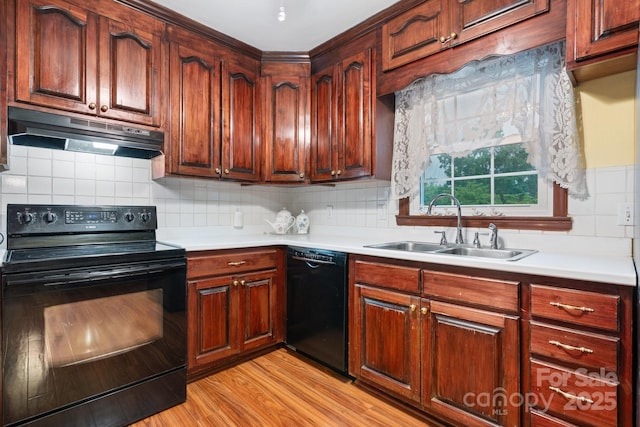 kitchen with light wood-type flooring, a sink, light countertops, black appliances, and under cabinet range hood
