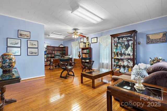 living room featuring ornamental molding, light wood-style flooring, and attic access