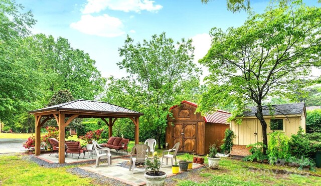 exterior space featuring a storage unit, a gazebo, outdoor lounge area, a patio area, and an outdoor structure