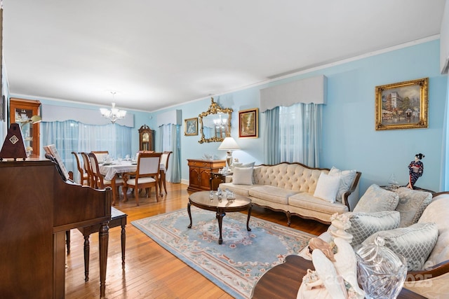 living area featuring crown molding, light wood-style flooring, and a notable chandelier