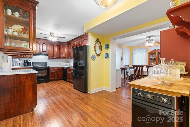 1287 Queensgate St, Gastonia, NC 28054 - kitchen with black appliances, ceiling fan, under cabinet range hood, and wood finished floors