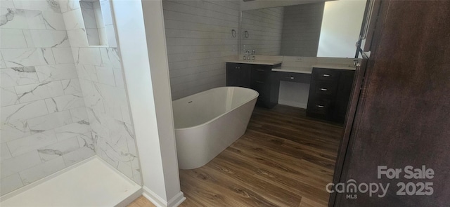 bathroom featuring a freestanding tub, walk in shower, wood finished floors, and vanity
