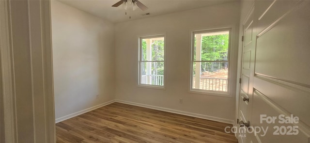 unfurnished room with baseboards, a ceiling fan, wood finished floors, and visible vents