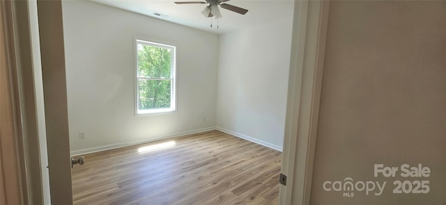 unfurnished room featuring wood finished floors, visible vents, a ceiling fan, and baseboards