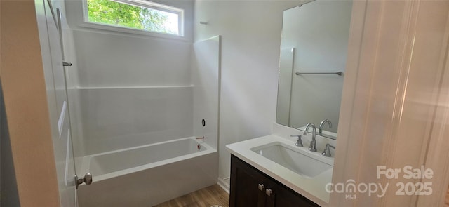 bathroom with vanity, wood finished floors, and  shower combination
