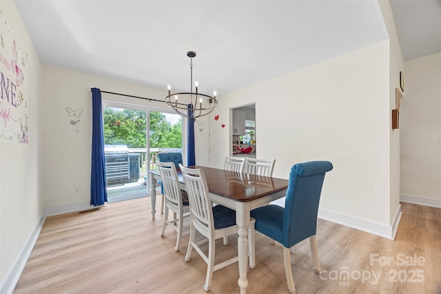1009 Rainbow Cir, Catawba, SC 29704 - dining space featuring a chandelier, light wood-style floors, and baseboards