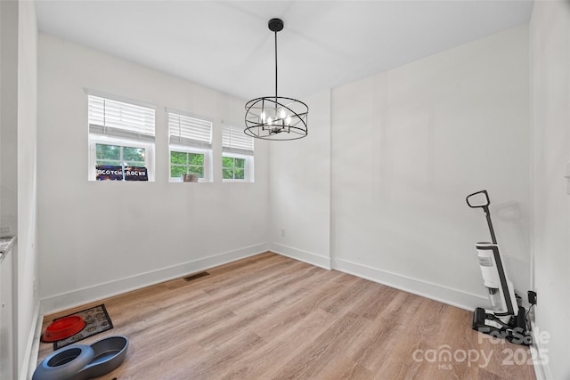 1009 Rainbow Cir, Catawba, SC 29704 - unfurnished dining area with light wood-type flooring, baseboards, and a chandelier