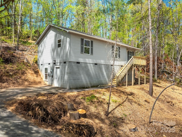 exterior space with crawl space, a wooden deck, and stairway