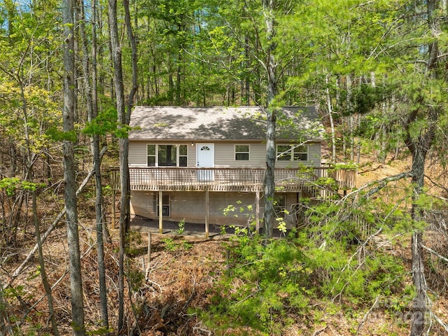 rear view of property with roof with shingles and a deck
