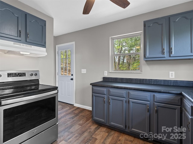 kitchen featuring blue cabinets, dark countertops, stainless steel range with electric cooktop, dark wood-style floors, and under cabinet range hood