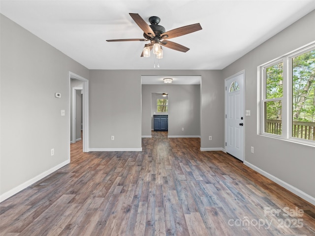 unfurnished living room featuring baseboards, ceiling fan, and wood finished floors