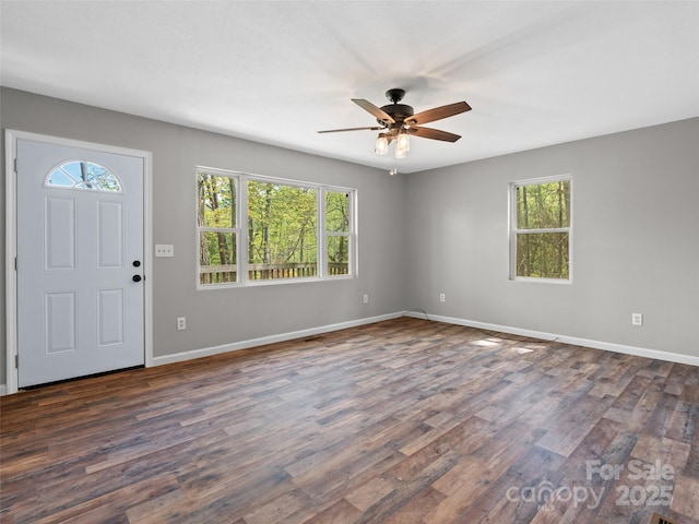 entrance foyer with dark wood-style flooring, a ceiling fan, baseboards, and plenty of natural light