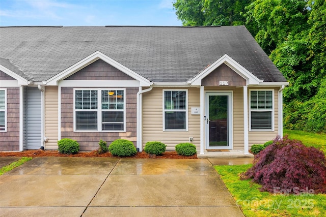 view of front of home featuring roof with shingles and a patio