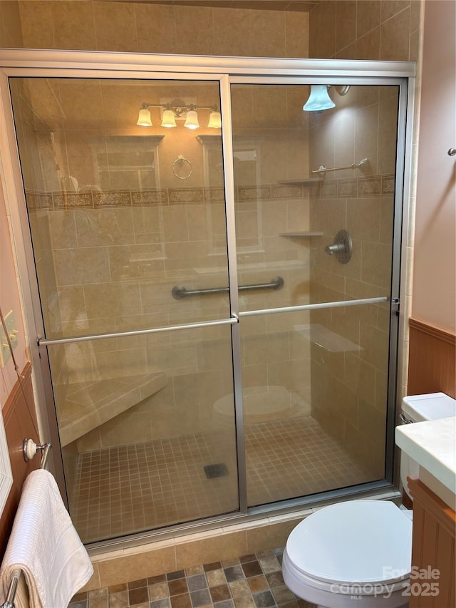 bathroom with toilet, a stall shower, and vanity