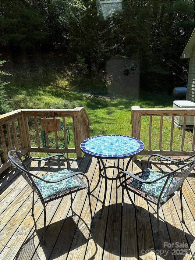 wooden terrace featuring a lawn and central AC unit