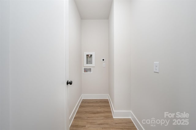 clothes washing area featuring laundry area, light wood-style floors, hookup for a washing machine, electric dryer hookup, and baseboards