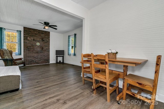 dining space featuring baseboards, a ceiling fan, and wood finished floors