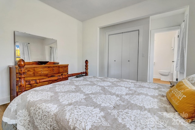 bedroom featuring baseboards, wood finished floors, and a closet