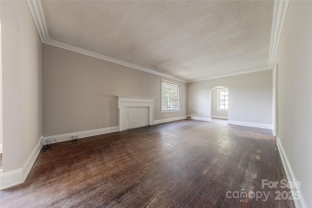 unfurnished living room featuring arched walkways, wood finished floors, and a textured ceiling