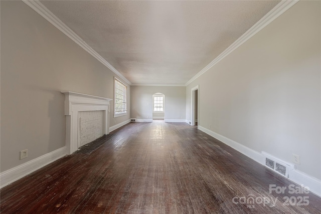 unfurnished living room with dark wood-type flooring, a brick fireplace, visible vents, and ornamental molding