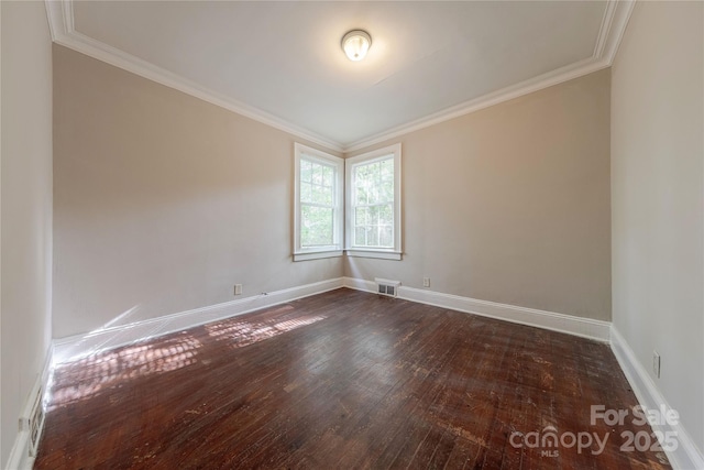 spare room with baseboards, visible vents, dark wood-style floors, and ornamental molding