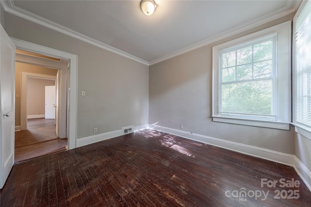 empty room featuring baseboards, crown molding, hardwood / wood-style floors, and visible vents