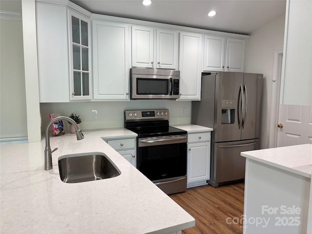 kitchen with dark wood-style floors, recessed lighting, white cabinetry, a sink, and appliances with stainless steel finishes