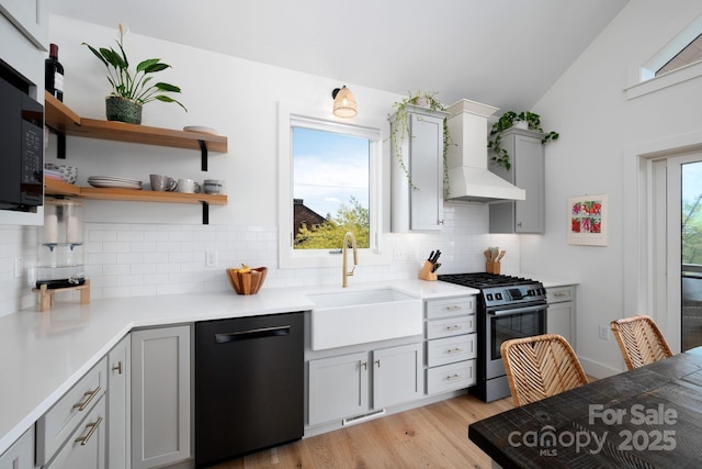 103 Pennsylvania Ave, Asheville, NC 28806 - kitchen with dishwashing machine, stainless steel range with gas stovetop, a sink, vaulted ceiling, and tasteful backsplash