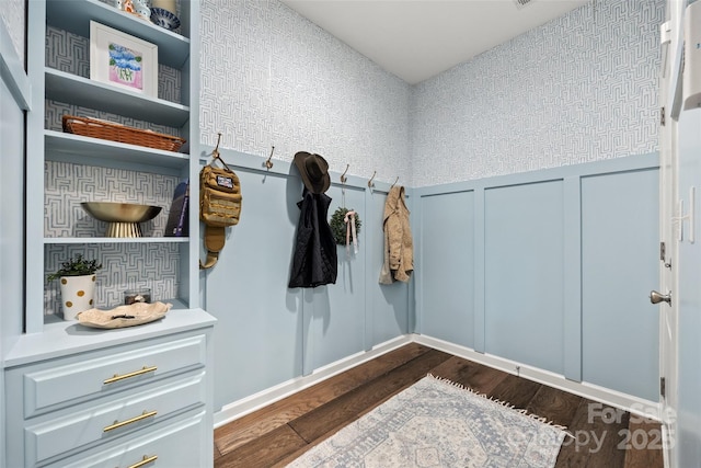 mudroom featuring dark wood finished floors, a decorative wall, and a wainscoted wall