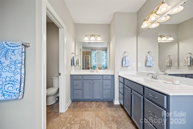 full bathroom with baseboards, toilet, a sink, and a stall shower