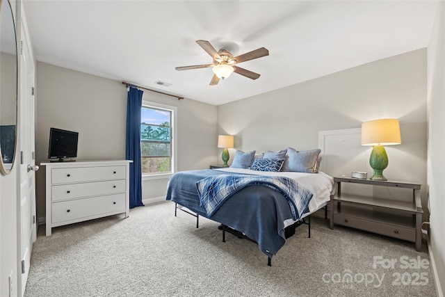 carpeted bedroom featuring baseboards, a ceiling fan, and visible vents