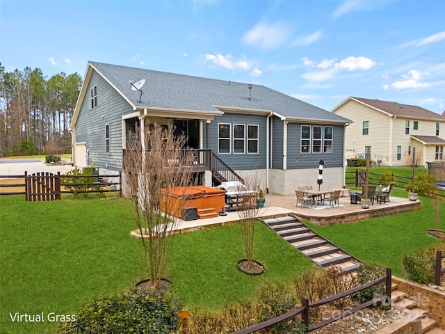 rear view of house featuring fence, a patio area, a lawn, and a hot tub