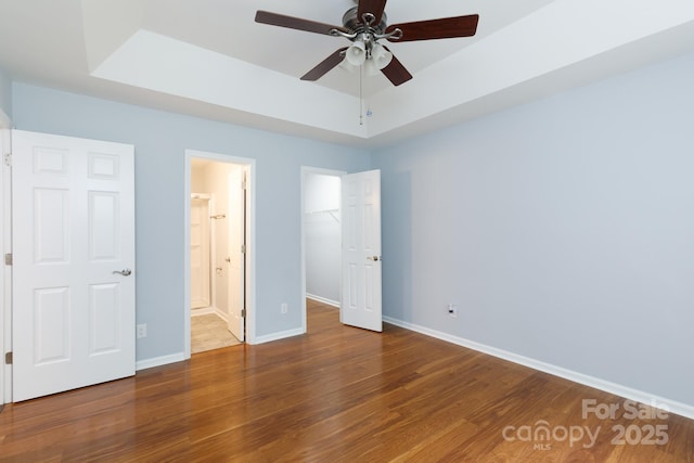 1455 Fieldcrest Cir, Rock Hill, SC 29732 - unfurnished bedroom featuring a tray ceiling, wood finished floors, a spacious closet, and baseboards