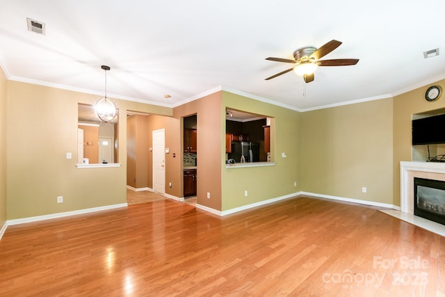 unfurnished living room featuring a ceiling fan, light wood-style floors, and visible vents