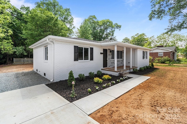 single story home with a porch, brick siding, and crawl space