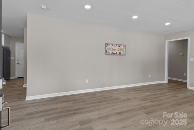 unfurnished room featuring baseboards, recessed lighting, and light wood-style flooring