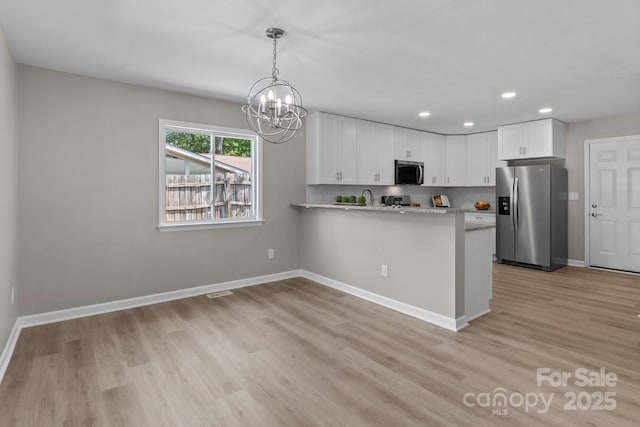 kitchen with light wood-style floors, an inviting chandelier, stainless steel appliances, recessed lighting, and white cabinetry