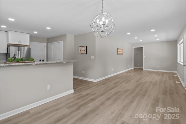 interior space featuring an inviting chandelier, baseboards, light wood-style floors, and recessed lighting