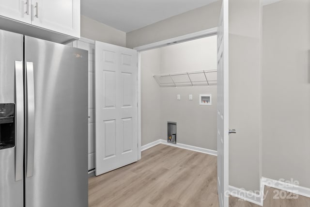laundry room featuring baseboards, laundry area, and light wood-type flooring