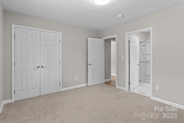 unfurnished bedroom with carpet flooring, baseboards, ensuite bath, and a closet