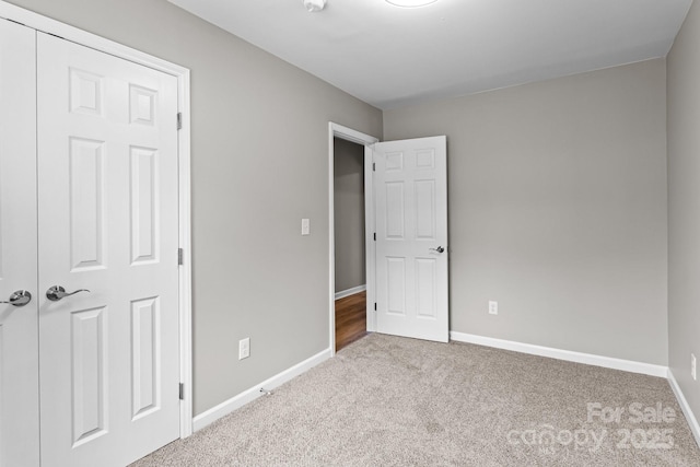 unfurnished bedroom featuring baseboards and carpet flooring