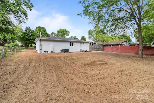 back of property with central AC and fence