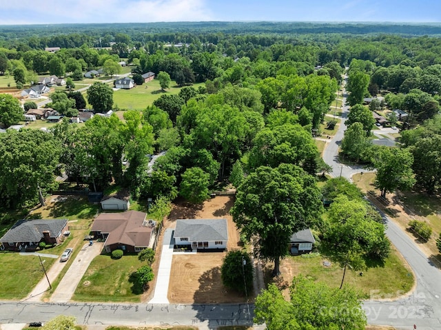 birds eye view of property featuring a wooded view and a residential view