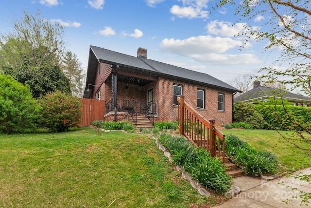 24 Enka Orchard St, Candler, NC 28715 - view of front of property featuring fence, a chimney, brick siding, and a front yard