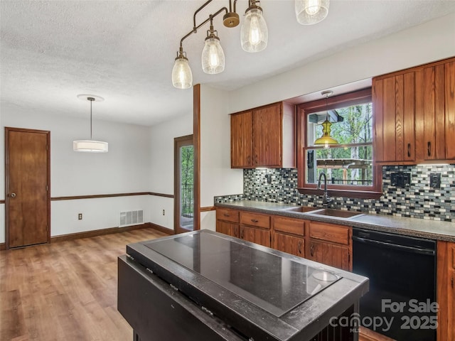 kitchen featuring a sink, tasteful backsplash, visible vents, brown cabinetry, and dishwasher