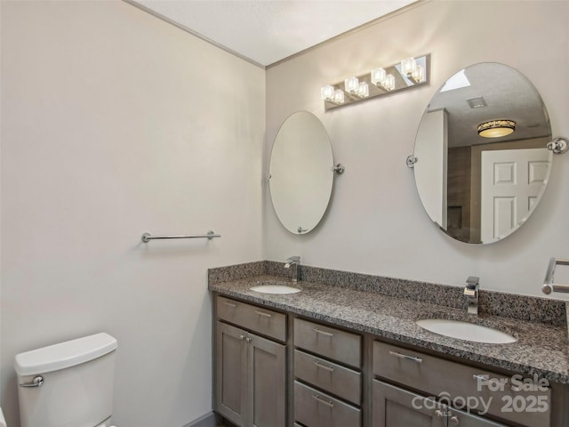full bathroom featuring toilet, a sink, and double vanity