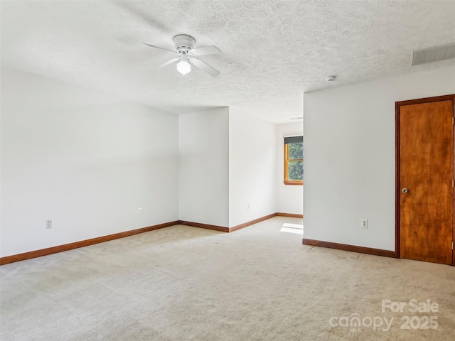 spare room with a ceiling fan, baseboards, and light colored carpet