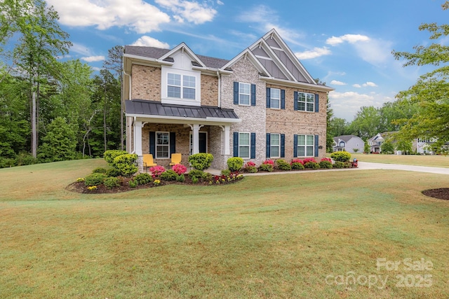craftsman inspired home featuring brick siding, a front lawn, a porch, and a standing seam roof